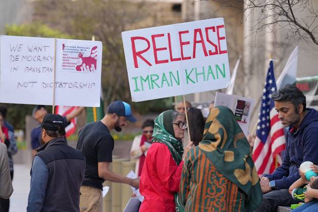 A group of people holding signs  Description automatically generated