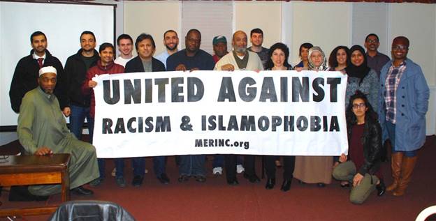 A group of people holding a banner Description automatically generated