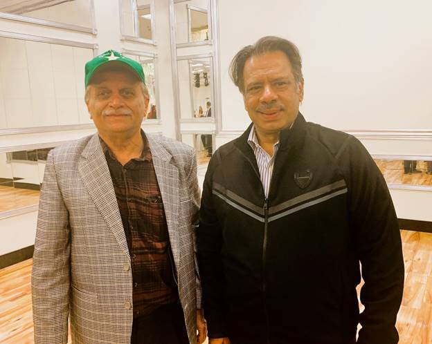 Two men standing together smiling  Description automatically generated