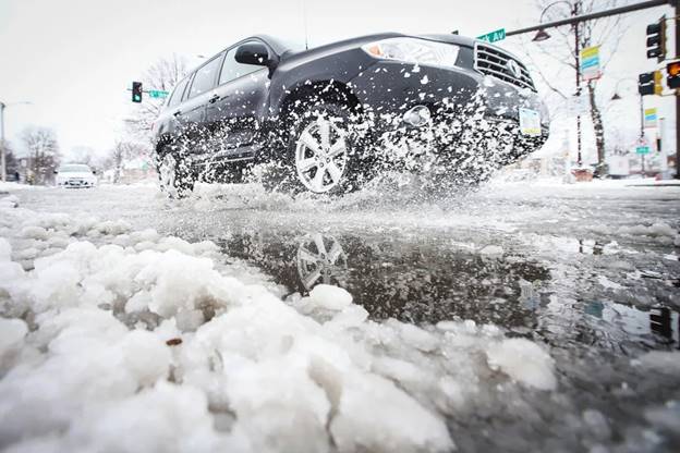 A car passes through snow on Clark Avenue after a snowstorm (Nirmalendu Majumdar / USA Today Network)
