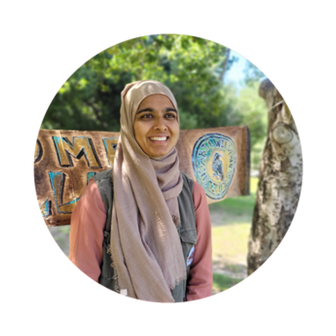 A person smiling in a scarf Description automatically generated