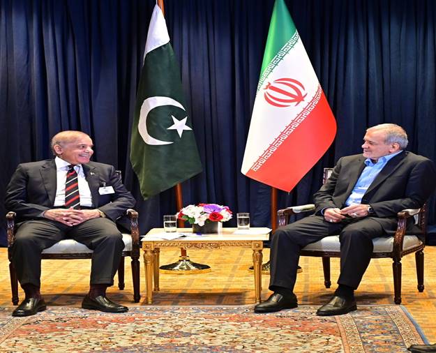 Two men sitting in chairs with flags Description automatically generated