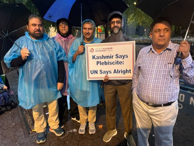 A group of people holding a sign Description automatically generated