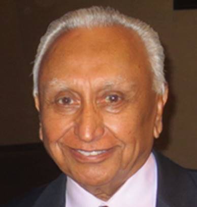 A person with white hair wearing a suit and tie Description automatically generated
