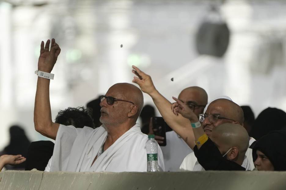 Pilgrims casting stones at a pillar in symbolic stoning of the devil near Mecca, Saudi Arabia