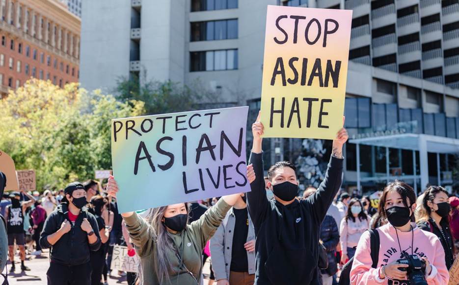 A group of people holding signs Description automatically generated