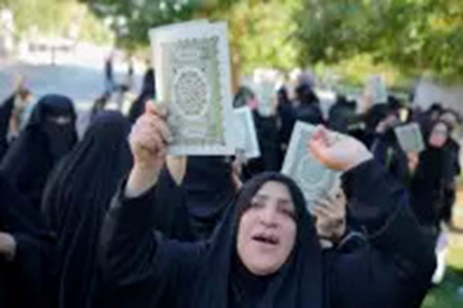 Iraqis raise copies of the Quran, Muslims' holy book, during a protest in Baghdad, Iraq, Saturday, July 22, 2023. Hundreds of protesters have attempted to storm Baghdad’s heavily fortified Green Zone, which houses foreign embassies and the seat of Iraq’s government, following reports of the burning of a Quran by a ultranationalist group in front of the Iraqi Embassy in Copenhagen. (AP Photo/Hadi Mizban)