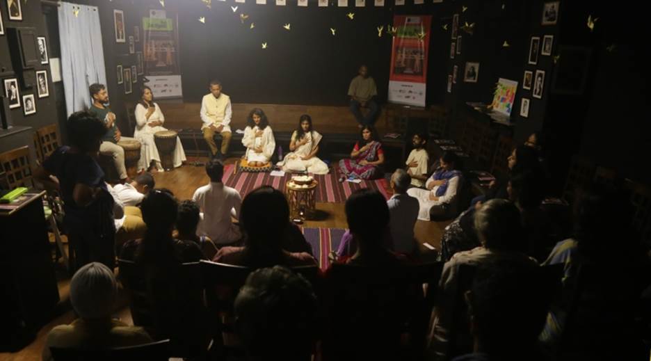 A group of people sitting on a stage Description automatically generated with medium confidence