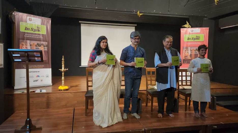 A group of people standing on a stage holding papers  Description automatically generated with medium confidence