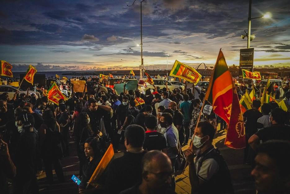 A group of people holding flags and protesting  Description automatically generated