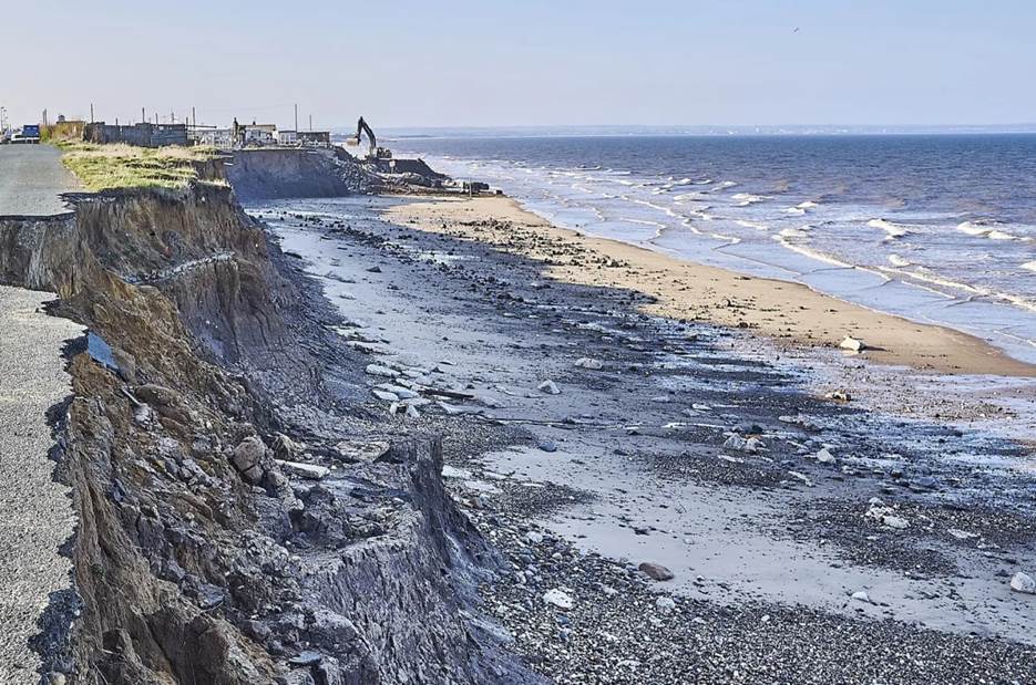 A rocky beach with a body of water  Description automatically generated