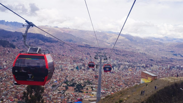 A cable car going over a city  Description automatically generated