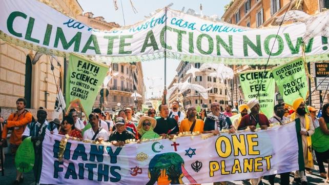 A group of people holding banners Description automatically generated