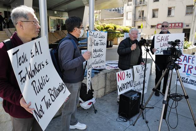 A group of people holding signs  Description automatically generated