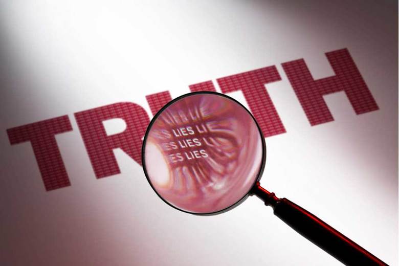 Close-up of a magnifying glass over a truth Description automatically generated