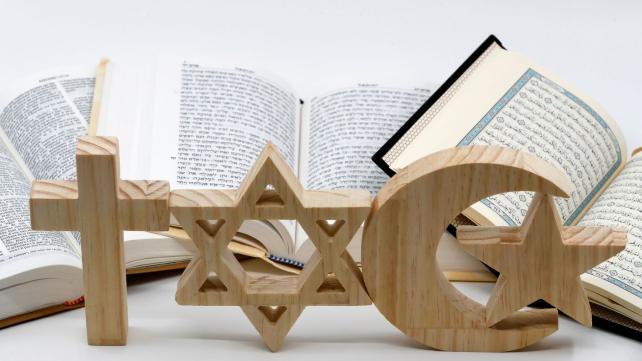A wooden sign with a star and crescent moon Description automatically generated