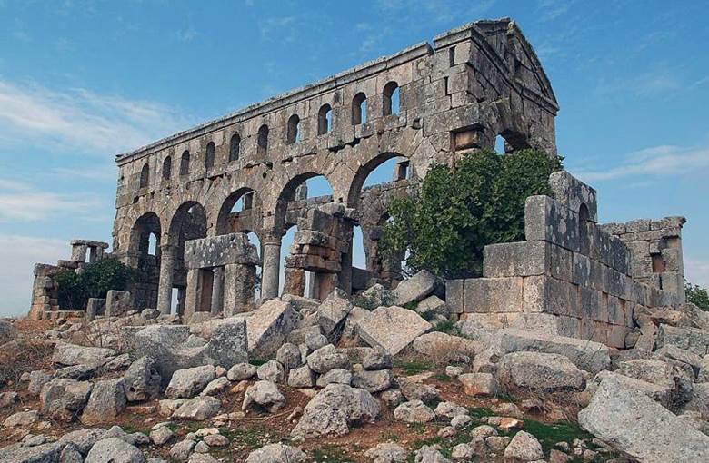An old stone building with many arches Description automatically generated