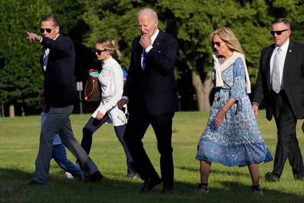 President Joe Biden, center, walks with his family on the grass at Fort Lesley J. McNair in Washington, D.C. (Jacquelyn Martin / AP)