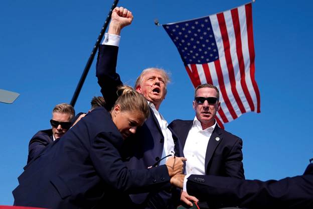 Former President Donald Trump is surrounded by U.S. Secret Service agents at a campaign rally where he was shot at and wound on Saturday, July 13, in Butler, Pa.