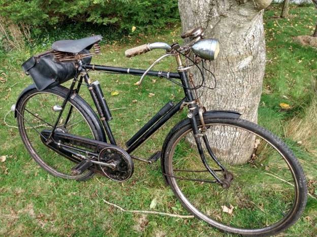 A bicycle leaning against a tree  Description automatically generated