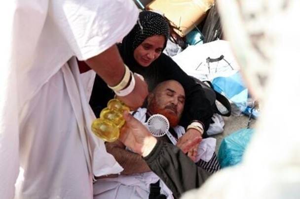 A pilgrim affected by scorching heat is helped by other Muslims in Mina, near Saudi Arabia's holy city of Mecca