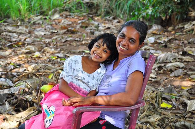 A person and a child sitting in a chair  Description automatically generated