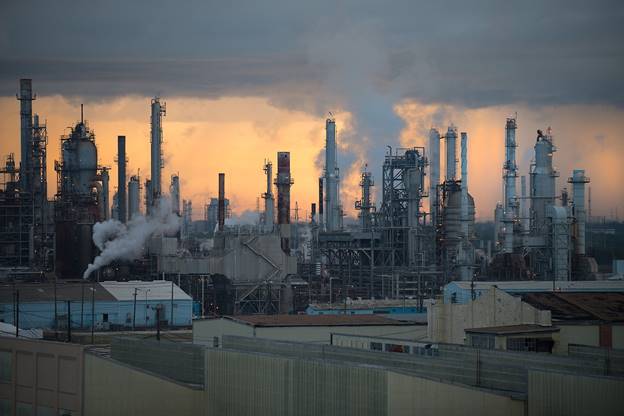 A factory with smokestacks and clouds  Description automatically generated