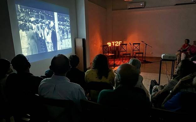 A group of people watching a projector screen  Description automatically generated