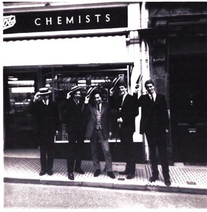 A group of men standing outside a store  AI-generated content may be incorrect.