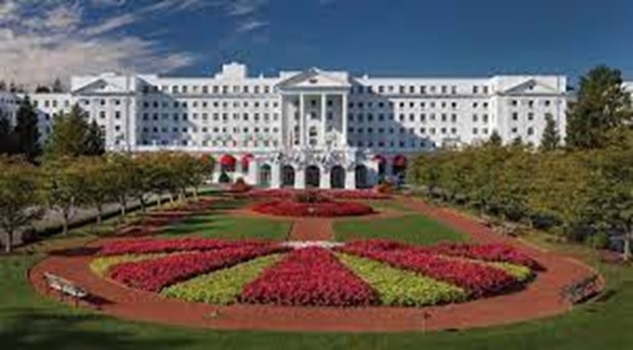 A large white building with a garden with The Greenbrier in the background  AI-generated content may be incorrect.