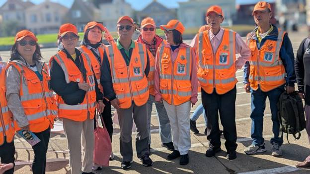 A group of people in orange vests  AI-generated content may be incorrect.